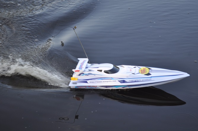 white rc boat cruising in water