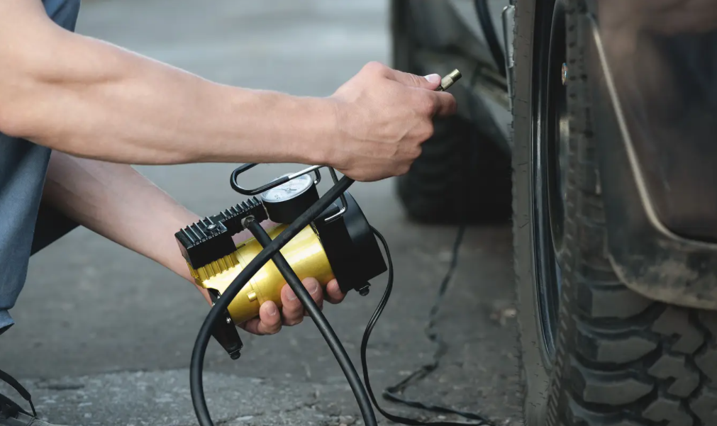 Man inflating tires with 12v air compressor