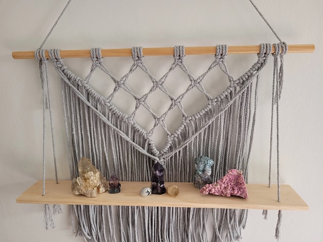 Close-up of macrame shlef with decor items on it