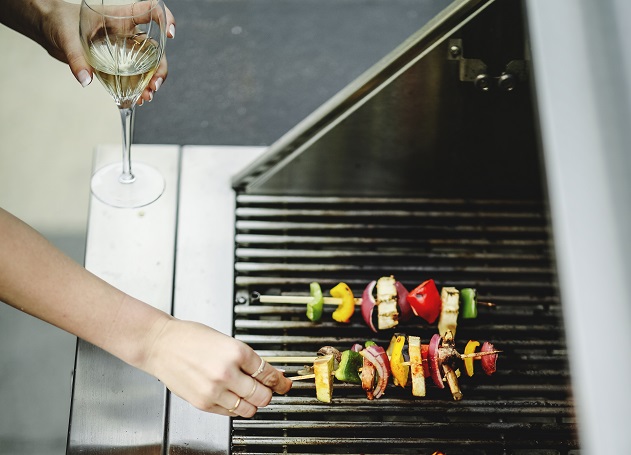 woman cooking skewer on a grill